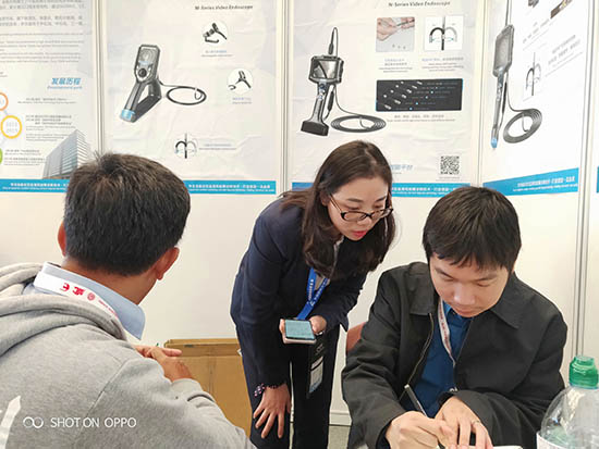 亞泰光電展臺前，公司內窺鏡工程師與客戶親密交談為